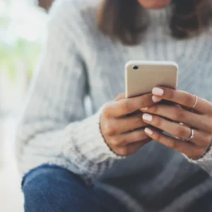 Woman displays importance of mobile first design by browsing the web on her phone